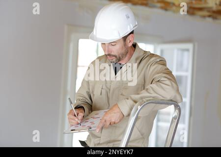 contremaître vérifiant les papiers de construction dans le presse-papiers Banque D'Images