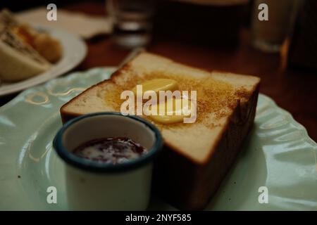 Beurre sur un toast épais avec un côté de la confiture étalé Banque D'Images