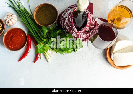 Concept gastronomique géorgien traditionnel avec épices, sauces et vins sur table en béton Banque D'Images
