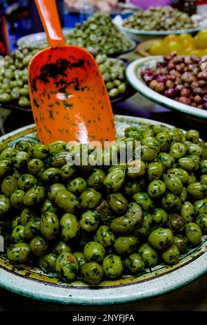 Au-dessus des olives vertes mûres avec une pelle dans un bol en métal placé sur la cale sur le marché local en Mauritanie Afrique Banque D'Images