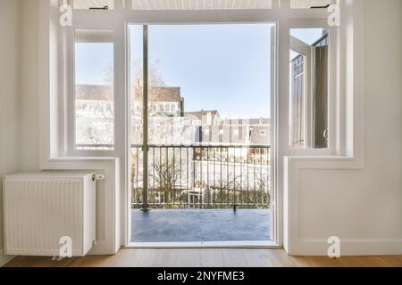 Appartement contemporain avec porte vitrée donnant sur un balcon avec clôture et bâtiments résidentiels Banque D'Images