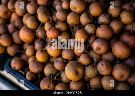Longans bruns exposés à la vente sur un marché local Banque D'Images