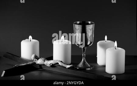 calice doré avec crucifix et bougies allumées, noir et blanc Banque D'Images