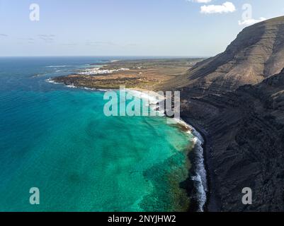 Vue aérienne de la plage paradisiaque avec l'eau turquoise avec littoral protégé par des montagnes bâillonnées dans les îles canaries orzola lanzarote. Banque D'Images