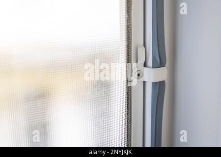 Installation anti moustiquaire sur la fenêtre pour protéger contre les insectes, crochet de fixation gros plan. Banque D'Images