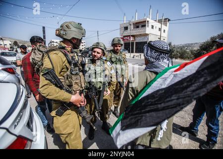 Naplouse, Palestine. 02nd mars 2023. Un homme palestinien âgé fait passer le drapeau palestinien devant les soldats israéliens lors d'une protestation contre les attaques des colons juifs et la fermeture des magasins commerciaux par l'armée israélienne dans la ville de Hawara, au sud de Naplouse, en Cisjordanie occupée. Crédit : SOPA Images Limited/Alamy Live News Banque D'Images