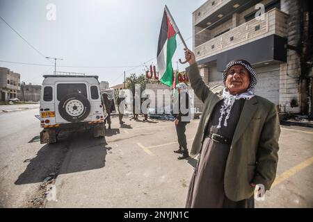 Naplouse, Palestine. 02nd mars 2023. Un homme palestinien âgé fait passer le drapeau palestinien devant les soldats israéliens lors d'une protestation contre les attaques des colons juifs et la fermeture des magasins commerciaux par l'armée israélienne dans la ville de Hawara, au sud de Naplouse, en Cisjordanie occupée. Crédit : SOPA Images Limited/Alamy Live News Banque D'Images