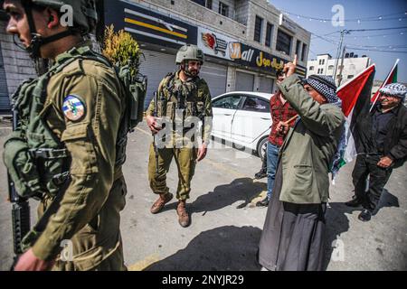 Naplouse, Palestine. 02nd mars 2023. Un palestinien âgé défend avec les soldats israéliens tout en levant le drapeau palestinien lors d'une protestation contre les attaques des colons juifs et la fermeture des magasins commerciaux par l'armée israélienne dans la ville de Hawara, au sud de Naplouse, en Cisjordanie occupée. (Photo de Nasser Ishtayeh/SOPA Images/Sipa USA) crédit: SIPA USA/Alay Live News Banque D'Images