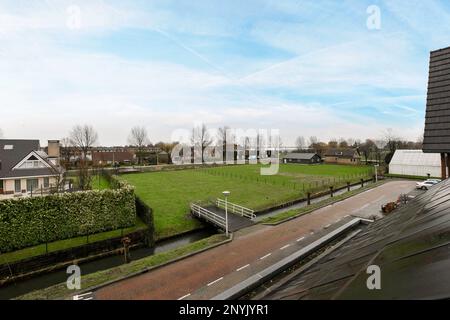 Amsterdam, pays-Bas - 10 avril 2021 : une petite ville avec des maisons en arrière-plan et une rivière qui la traverse, vue depuis une fenêtre d'appartement Banque D'Images