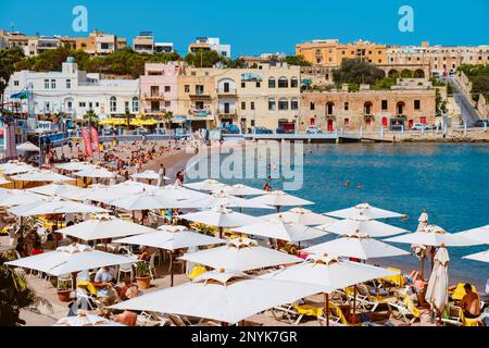 St Julians, Malte - 5 septembre 2022: Une foule de gens apprécient le bon temps d'une journée d'été sur la plage de la baie de St Georges, à St Julians, Malte Banque D'Images