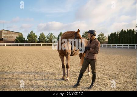 Femme pilote passant du temps avec son cheval préféré en plein air Banque D'Images