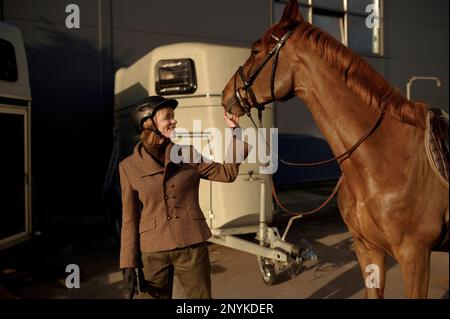 Jeune adulte rider souriant femme qui a le nez d'un cheval Banque D'Images