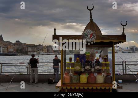 Les pêcheurs et de blocage de l'alimentation sur la Corne d'or, dans le district d'Eminonu près de pont de Galata, en arrière-plan quartier de Beyoglu, Istanbul. La Turquie Banque D'Images