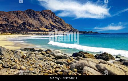 Magnifique baie isolée déserte sur la côte rocheuse de l'océan pacifique, petite plage de sable vide, eau bleue, montagne sauvage - nord du Chili, région d'Atacama, Banque D'Images