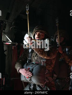 Un parachutiste de l'armée italienne avec la Brigade parachutiste Folgore attend des commandes de saut dans un avion C-130 Hercules au cours d'une opération aérienne avec les États-Unis Parachutistes de l'armée de la Brigade aéroportée 173rd à la zone de Juliet Drop, Pordenone, Italie, 26 janvier 2023. La Brigade aéroportée de 173rd est la U.S. La Force de réaction en cas d'urgence de l'armée en Europe, fournissant des forces rapidement déployables aux États-Unis les domaines de responsabilité de l'Europe, de l'Afrique et du Commandement central. Forward déployée en Italie et en Allemagne, la brigade s'entraîne régulièrement aux côtés des alliés et partenaires de l'OTAN pour établir des partenariats et des Banque D'Images