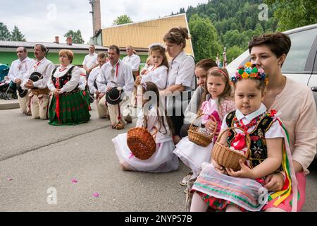 Adorateurs de village, enfants dans des vêtements traditionnels, célébration de Corpus Christi à Tokarnia, village de Gorals (peuple polonais des highlander), chaîne de montagnes de Beskids, Carpates occidentales, région de Malopolska, Pologne Banque D'Images