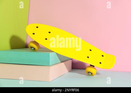 Planche à roulettes jaune sur fond de couleur. Équipement de sport Banque D'Images