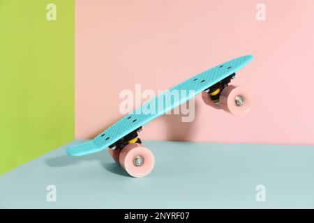 Planche à roulettes turquoise sur fond de couleur. Équipement de sport Banque D'Images
