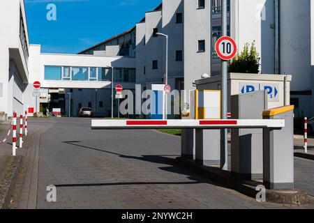 Barrière bloquant la route pour le stationnement payant à l'intérieur de la cour. Bâtiment administratif blanc. Banque D'Images