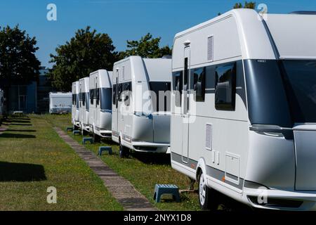 Une rangée de caravanes blanches sur pied sur une journée ensoleillée en été avec un ciel bleu. Banque D'Images