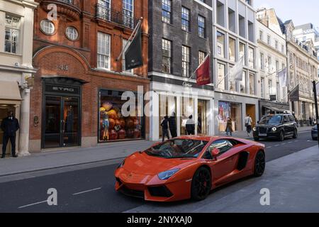 Orange Lamborghini parqué sur Old Bond Street, les rues commerçantes les plus luxueuses de Londres pour les vêtements et bijoux de créateurs, Angleterre, Royaume-Uni Banque D'Images