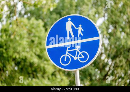 Chemin pour les piétons partagé avec une piste cyclable, piste cyclable bleu panneau polonais sur la rue, proximité d'objet, détail, personne. Vélo en Europe Banque D'Images