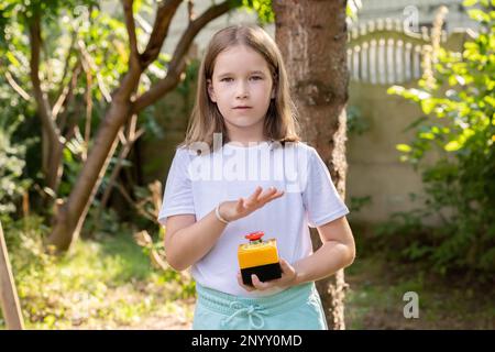 Jeune fille d'âge scolaire sur le point d'appuyer sur un gros bouton d'arrêt d'urgence industriel rouge, alarme, action d'arrêt, urgence attention simple concept, un pe Banque D'Images