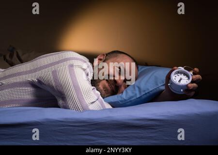 Réveil pour un homme qui se trouve sur le lit et sourit. Facilité de réveil, bonne nuit de sommeil, le bon mode pour. Banque D'Images