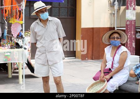 Couple Latino plus ancien avec masque de protection et chapeau marchant sur la plaza, nouveau normal Covid-19 Banque D'Images