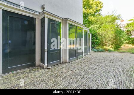 Amsterdam, pays-Bas - 10 avril 2021 : l'extérieur d'un bâtiment avec fenêtres et portes qui sont fermées pour laisser entrer une certaine lumière du soleil qui brille à travers les arbres Banque D'Images