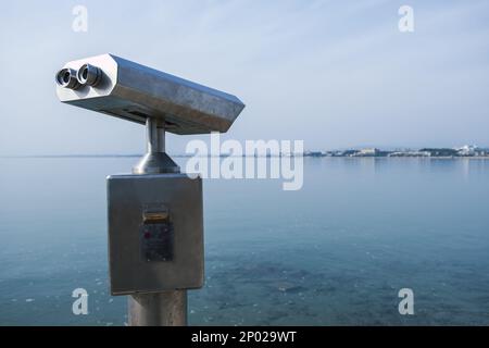 Jumelles électroniques à pièces pour les touristes sur un paysage marin à Antalya Turquie. Banque D'Images