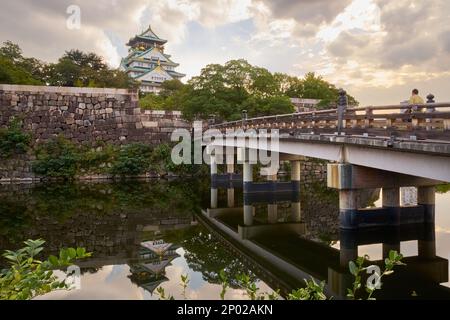 Un pont de fossé avec des reflets du château dans l'eau menant au majestueux château d'Osaka (Osakajo) à Osaka, Japon Banque D'Images