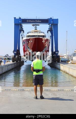 Didim, Aydin, Turquie. 20 juin 2022: Le méga yacht est levé par une grande grue avec le contrôle de l'opérateur pour l'entretien sur terre. Mise au point sélective. Banque D'Images