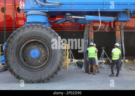 Didim, Aydin, Turquie. 20 juin 2022 : l'immense roue de la grue transportant le yacht Mega étant entretenue sur terre et les techniciens travaillant ne Banque D'Images