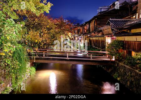 Un pont en bois éclairé menant à des restaurants japonais traditionnels en bois à Kyoto, au Japon Banque D'Images