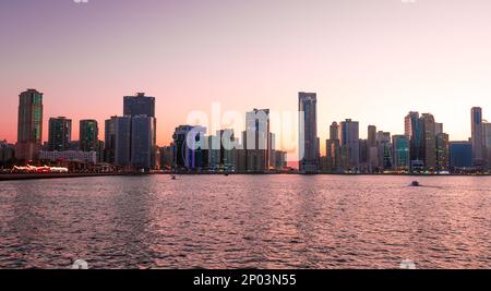 Coucher de soleil paysage de Sharjah gratte-ciel au-dessus de l'eau dans les Émirats Arabes Unis Banque D'Images