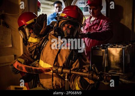 Le pompier Joseph, centre, affecté au quai de transport amphibie de classe San Antonio USS Arlington (LPD 24), se prépare à être soulagé comme le nozzleman lors d'un exercice de forage de quartiers généraux en cours dans l'océan Atlantique, le 10 février 2023. Les marins d'Arlington maintiennent la maîtrise des dommages en effectuant des exercices de routine à la fois à l'intérieur et en cours. Banque D'Images