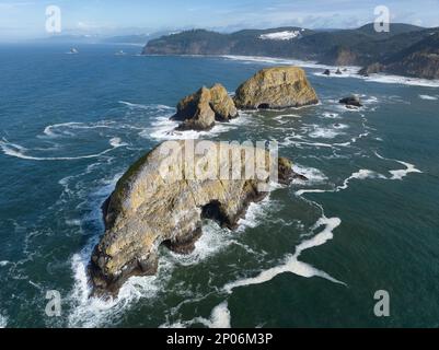 La lumière du soleil brille sur des tas de mer accidentés au large de la côte nord de l'Oregon, non loin de Tillamook. Ce littoral a de nombreux points de vue remarquables. Banque D'Images