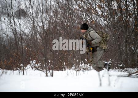 Le SPC Brandon Negrete, un medic affecté aux observateurs avant du 1-120th Field Artillery Regiment, réagit à une attaque simulée lors de la grève du Nord 23-1, le 24 janvier 2023, au Camp Grayling, au Michigan. Les unités qui participent à la phase d’hiver de la grève du Nord sont prêtes en menant une formation conjointe par temps froid conçue pour atteindre les objectifs de la Stratégie pour l’Arctique du ministère de la Défense. Banque D'Images