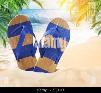 Tongs rayées sur une plage de sable près de la mer Banque D'Images