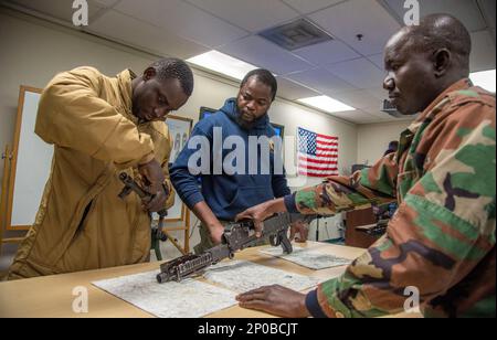 Le capitaine Abdoul Aziz Moumouni, un instructeur de la nation partenaire (PNI) de l'école navale d'instruction et de formation technique pour les petits bateaux (NAVSCIATTS), donne des instructions pendant un cours d'officier de patrouille fluvial (PCOR) sur la façon de démonter et de remonter correctement une mitrailleuse M240B sur le centre spatial John C. Stennis, au Mississippi, au 6 février 2023. Moumouni est aussi traducteur français pendant les États-Unis de l'école Commandement de l'Afrique Banque D'Images