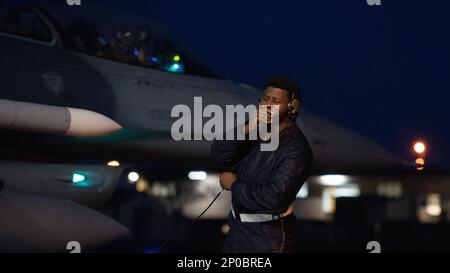 ÉTATS-UNIS Le sergent d'état-major de la Force aérienne Keon Purnell, un artisan avionique du 52nd Escadron de maintenance d'aéronefs, utilise un casque pour communiquer avec un pilote Faucon Fighting Faucon F-16cm affecté à l'escadron de combat 480th avant le décollage à la base aérienne de Spangdahlem, en Allemagne, le 11 janvier 2023. Les aviateurs travaillent 24 heures sur 24, souvent dans des conditions météorologiques moins favorables, pour que la mission de l'aile soit toujours prête. Banque D'Images