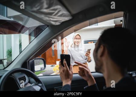 le chauffeur de transport en ligne montre son téléphone portable lors de la prise en charge du client Banque D'Images