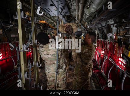 ÉTATS-UNIS Les aviateurs de la Force aérienne de l'escadron médical expéditionnaire 386th et de l'escadron d'évacuation aérienne expéditionnaire 405th chargent une litière sur les pinces d'un C-130J Super Hercules à la base aérienne Ali Al Salem (Koweït), le 8 février 2023. Aviateurs de l'EMDS 386th, EAES 405th, États-Unis Les Services de soutien aux vétérinaires du détachement médical de l'armée 109th et les partenaires de la coalition d'Italie et du Danemark se sont associés pour apprendre à préparer et à charger des patients sur un C-130J Super Hercules. Banque D'Images