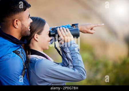 Jumelles, pointage et un couple observation d'oiseaux dans la nature tout en randonnée dans les montagnes ensemble. Forêt, nature ou tourisme avec un homme et une femme Banque D'Images