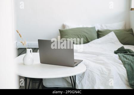 Ordinateur portable ouvert dans un intérieur moderne et confortable dans la chambre à la maison Banque D'Images