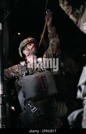 Un parachutiste de l'armée italienne avec la Brigade parachutiste Folgore accrochent sa ligne statique dans un avion Hercules C-130 au cours d'une opération aérienne avec les États-Unis Parachutistes de l'armée de la Brigade aéroportée 173rd à la zone de Juliet Drop, Pordenone, Italie, 26 janvier 2023. La Brigade aéroportée de 173rd est la U.S. La Force de réaction en cas d'urgence de l'armée en Europe, fournissant des forces rapidement déployables aux États-Unis les domaines de responsabilité de l'Europe, de l'Afrique et du Commandement central. Déployée en Italie et en Allemagne, la brigade s’entraîne régulièrement aux côtés des alliés et partenaires de l’OTAN pour construire des partenariats A. Banque D'Images