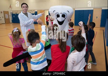 Tech. Le Sgt Katsiaryna durant, chef clinique dentaire de la dentisterie préventive de l’escadron médical 66th, et « M. Toothy » rendent visite à des enfants de l’école primaire de la base aérienne de Hanscom, Mass., 14 février. Les enfants ont participé à des jeux et à des activités visant à promouvoir de meilleurs soins dentaires et à observer le mois national de la santé dentaire des enfants. Banque D'Images