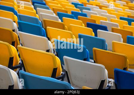 videz les sièges colorés sur les banquettes du stade. Banque D'Images