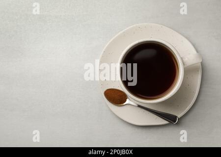 Tasse de délicieux chicorée et cuillère avec poudre sur table gris clair, vue du dessus. Espace pour le texte Banque D'Images